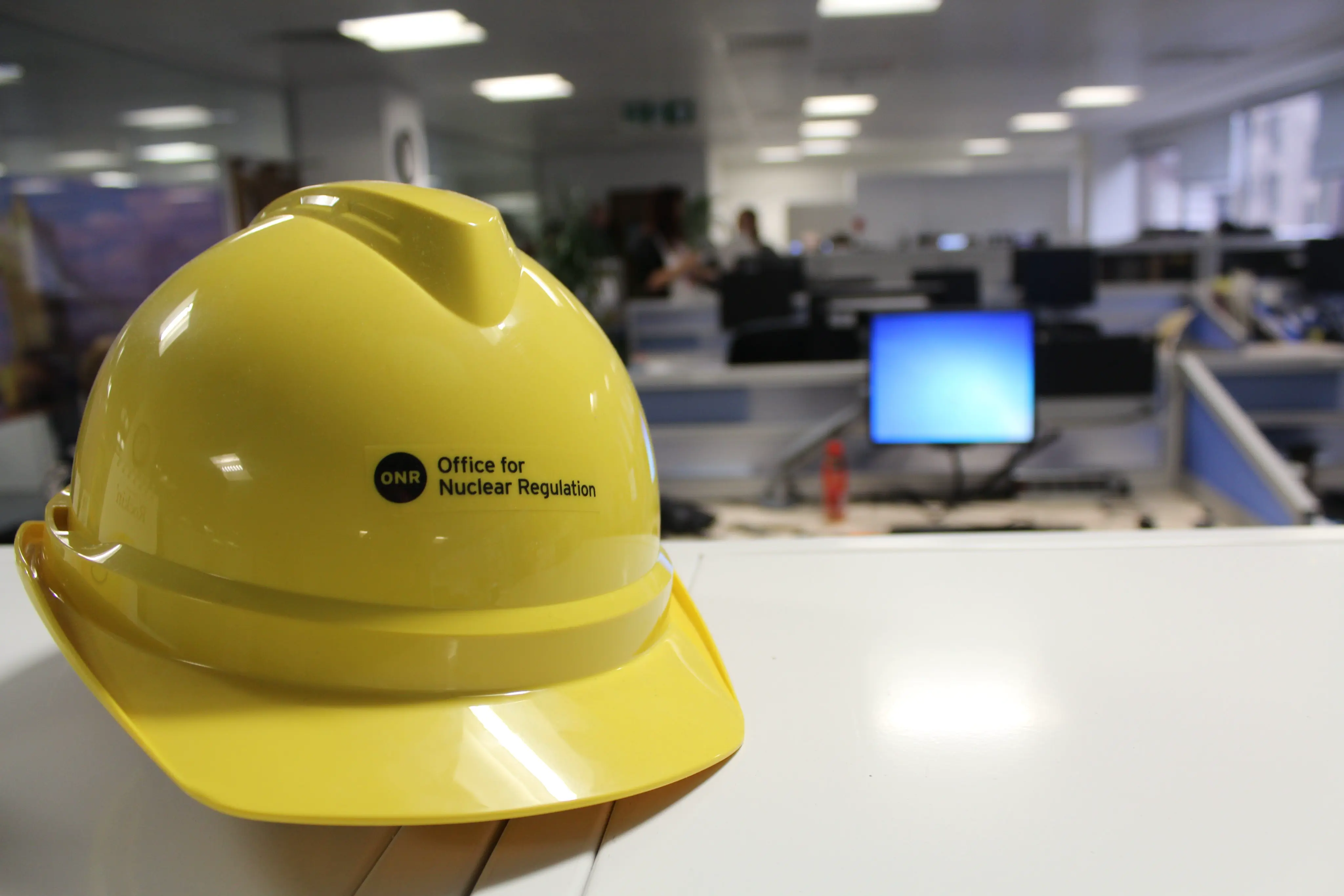 A hard hat with the ONR logo on it, in an office.